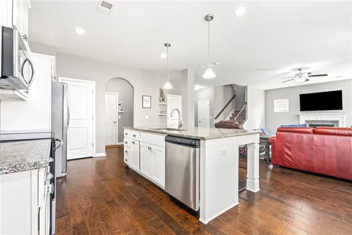 Rich hardwood flooring anchors the open kitchen, connecting seamlessly to a comfortable main living space.