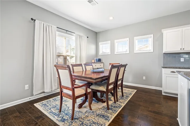 Rich hardwood flooring pairs beautifully with crown molding in this versatile dining space.