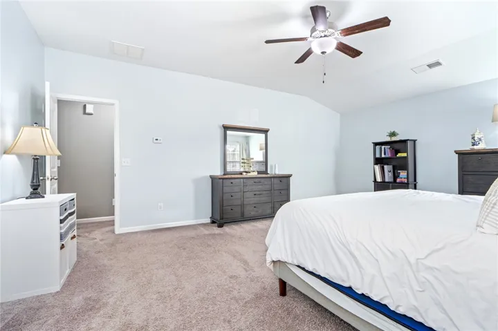 Vaulted ceilings and plush carpeting enhance this serene primary bedroom suite.