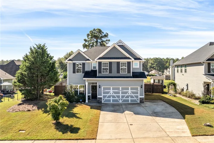 A classic facade showcasing clean lines, multi-textured siding, and a spacious paved driveway.