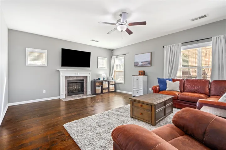 Rich hardwood flooring anchors this comfortable living area centered on a classic mantel fireplace.