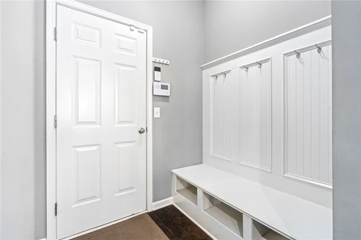 An inviting entryway features classic wainscoting and a functional built-in storage bench.