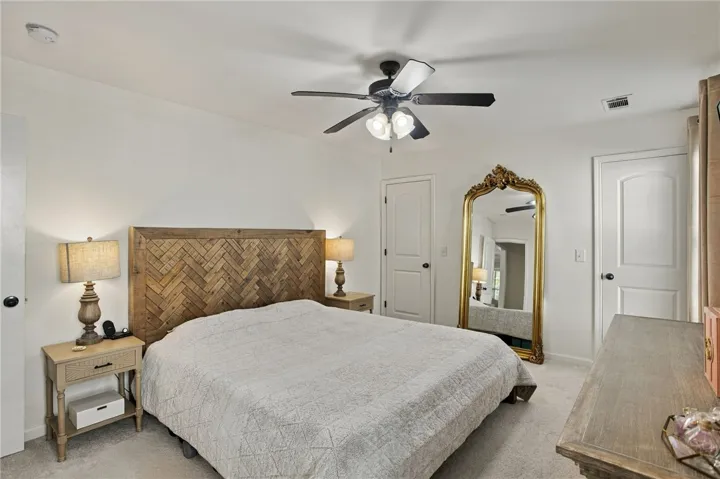 A tranquil sleeping space features neutral carpeting and classic paneled doors.