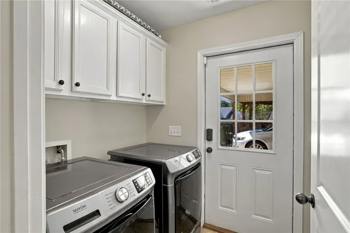 Crown molding frames the upper cabinetry in this functional utility space with private outdoor entry.