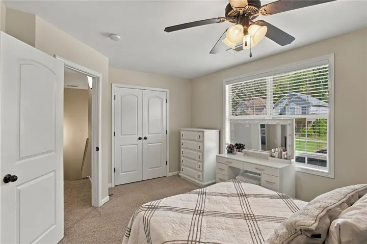Plush carpeting and abundant natural light create a welcoming and cozy bedroom space.