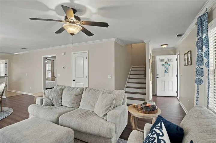 Rich hardwood flooring complements the crown molding in this welcoming open living space.