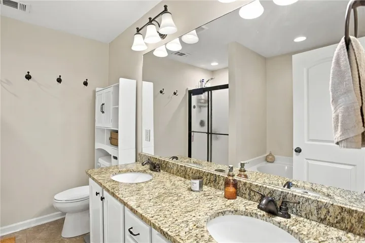 Warm granite counters and white cabinetry define this functional bath layout.
