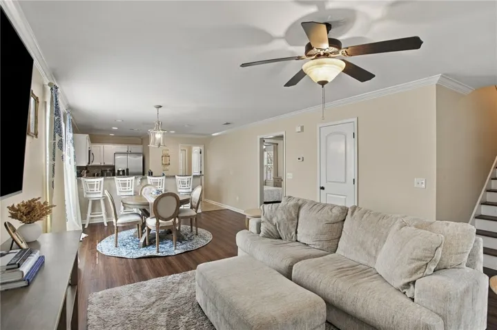 An open layout seamlessly connects the living space and dining area over warm wood-style flooring.