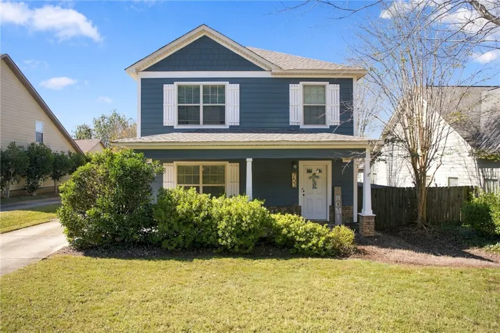 A welcoming front porch and classic shutters define this inviting two-story facade.
