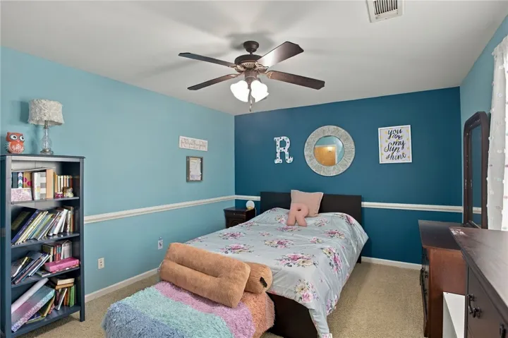 Plush carpet flooring pairs with traditional chair rail molding in this comfortable bedroom space.