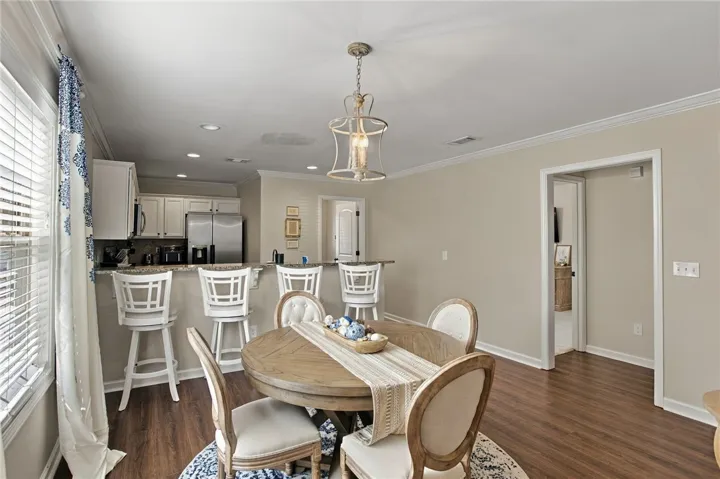 Gleaming hardwood floors and classic crown molding anchor this open dining space and kitchen.