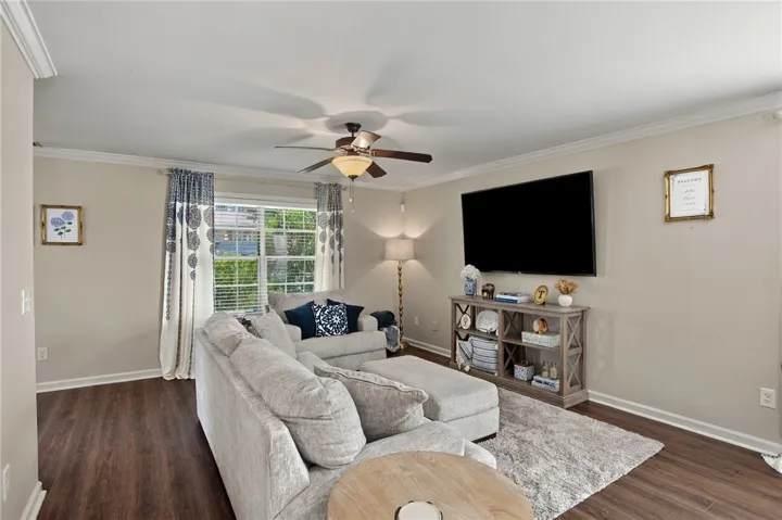 Rich wood-look flooring and elegant crown molding define this welcoming gathering space.