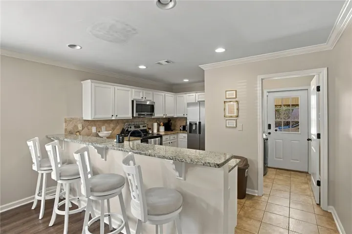 Polished granite counters and classic crown molding accent this functional kitchen design.
