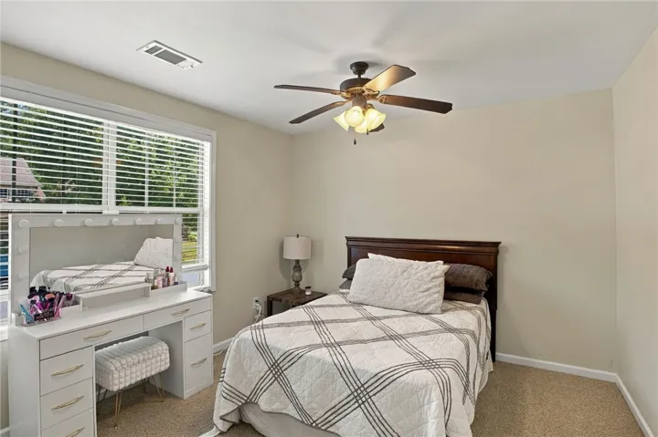 Plush carpeting and abundant natural light create a warm, inviting atmosphere in this bedroom.