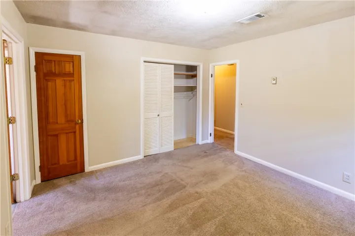 Soft carpeting underfoot defines this versatile bedroom complete with a built-in closet system.