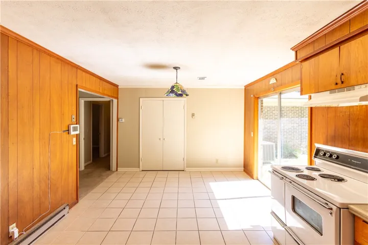 Rich wood paneling paired with tile flooring creates a classic mid-century culinary space.