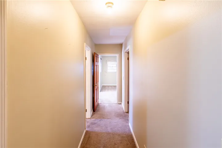 Plush carpeted floors guide you down a central hallway leading to private living spaces.