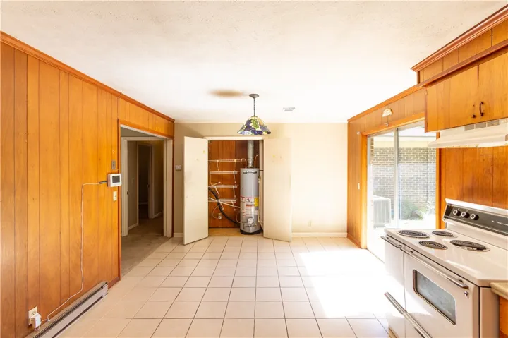 Classic wood paneling and durable tile flooring define this highly functional dining and kitchen space.