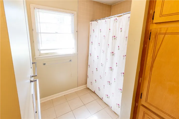 Tiled flooring and wood cabinetry define this functional bathroom space.