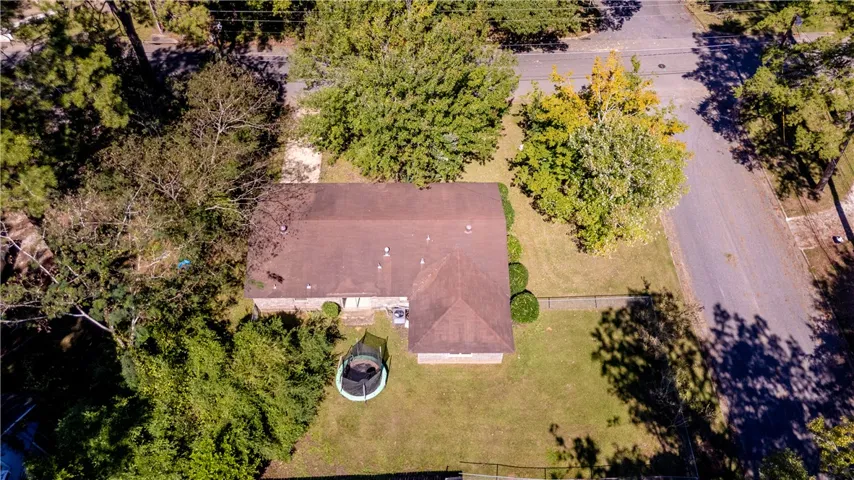 Mature trees frame the property, offering a bird's-eye perspective of the home and surrounding lawn.