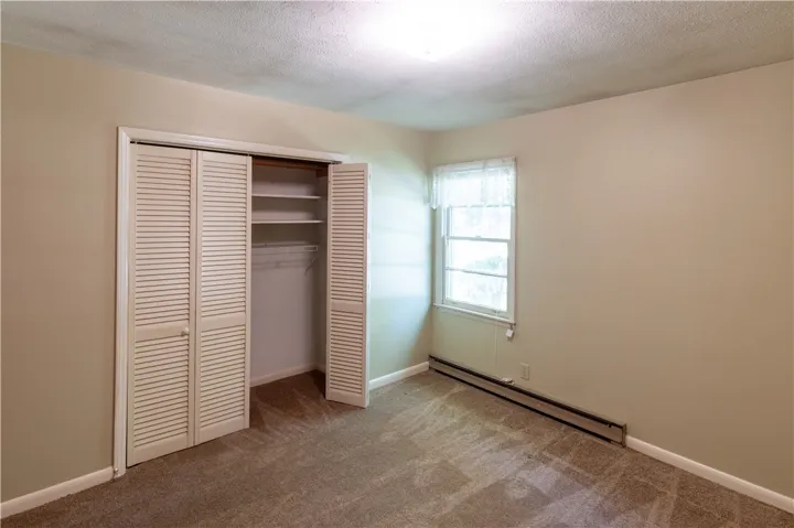 Plush carpeting and a louvered closet maximize space and comfort in this cozy bedroom.