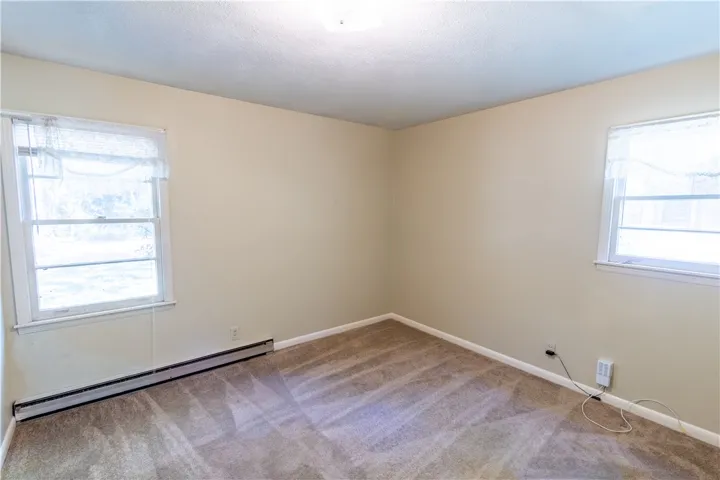 Natural light fills this quiet bedroom finished with plush wall-to-wall carpeting.