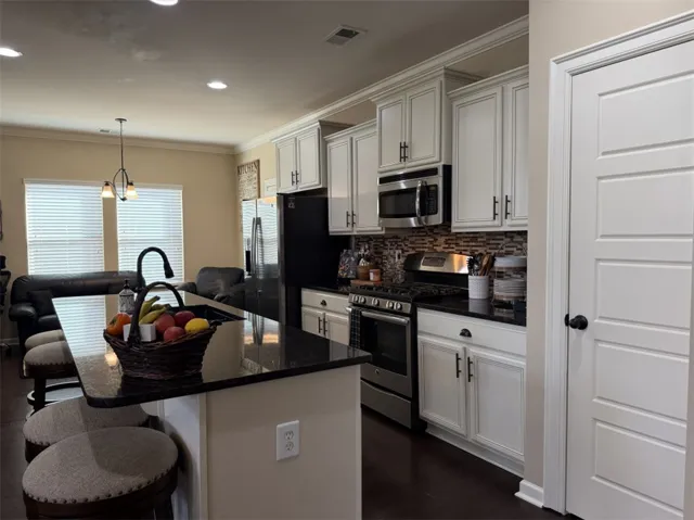 Granite countertops and classic cabinetry anchor this functional culinary workspace.