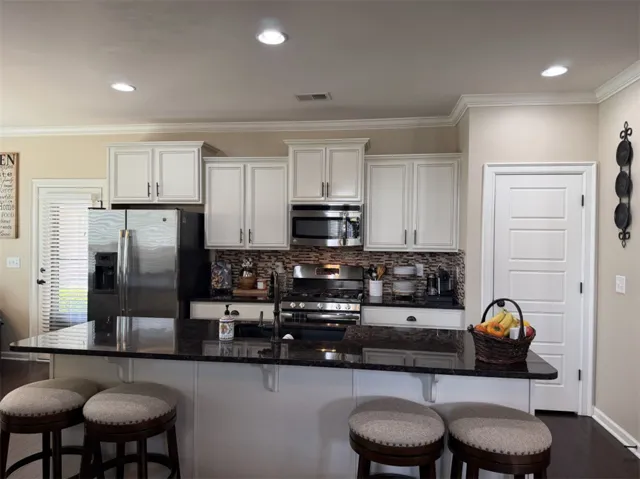 Gleaming stone countertops and matching cabinetry anchor this functional modern kitchen space.