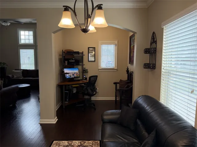 An arched opening connects the cozy sitting area to a private home office alcove.