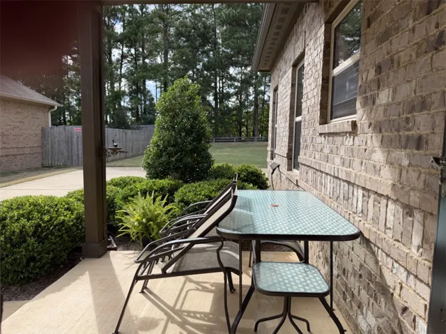 Brick exteriors frame this covered outdoor space overlooking a wooded yard.