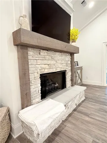 A classic floor-to-ceiling stone fireplace anchors the living space alongside durable wood-look flooring.