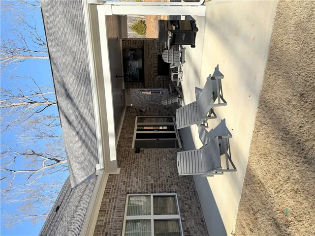 A spacious covered patio features a classic brick exterior and an integrated fireplace.