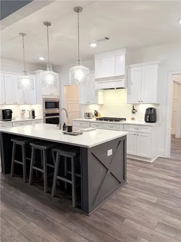 A spacious culinary workspace features modern cabinetry, solid countertops, and a central prep island.