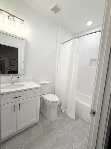 Crisp white finishes and clean tile work define this modern full bathroom.