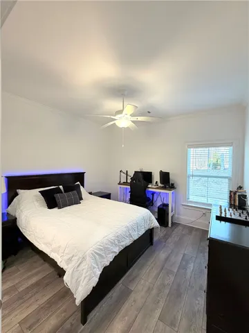 High ceilings and durable wood-look flooring enhance this versatile bedroom space.
