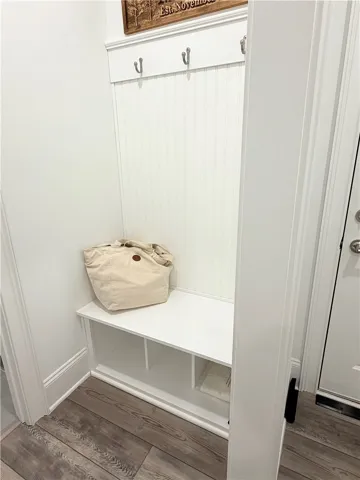 A functional built-in entry bench features wood-look flooring and wainscot paneling.