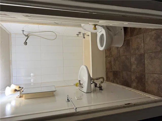 A classic three-piece layout features textured tiling and clean white wall panels.