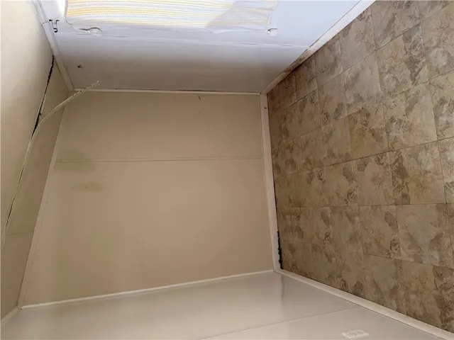 An alcove space features neutral-toned walls paired with practical vinyl tile flooring.
