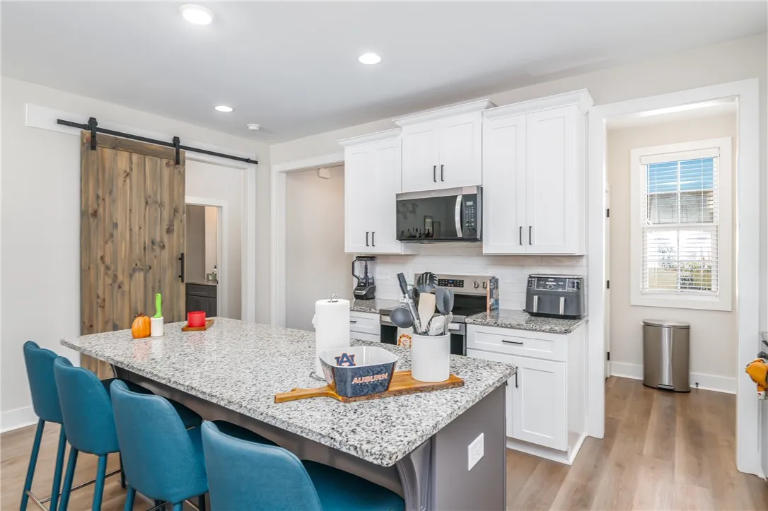 Granite countertops and clean white cabinetry anchor this modern kitchen with a central island.