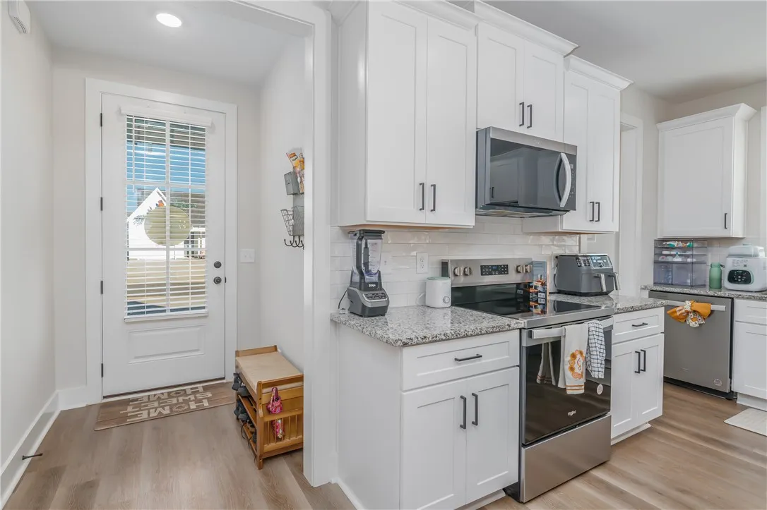 Gleaming granite countertops pair beautifully with clean white cabinetry and classic wood floors.