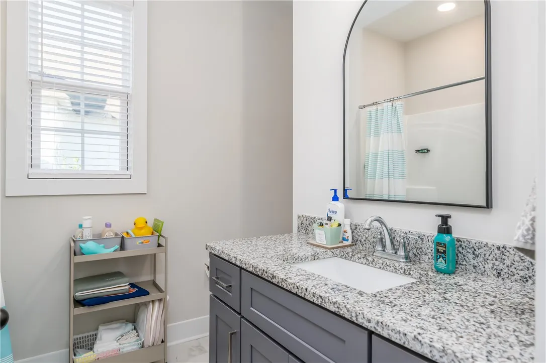 A classic vanity with granite counters anchors this beautifully detailed bath.