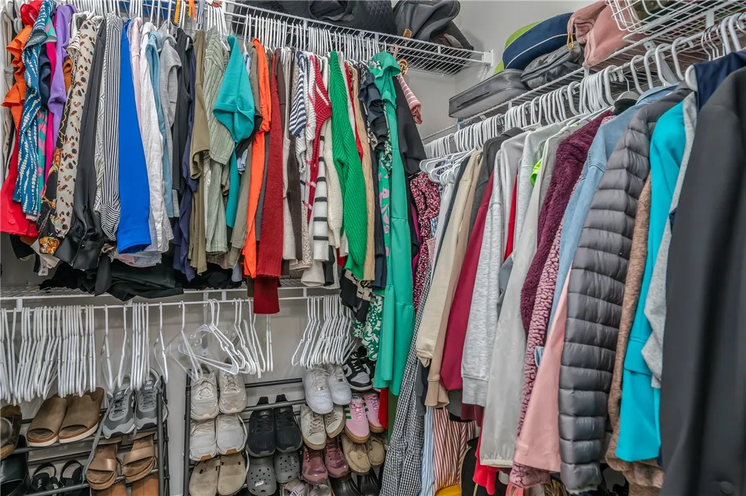 Ample wire shelving and hanging rods maximize storage capacity within this organized closet space.