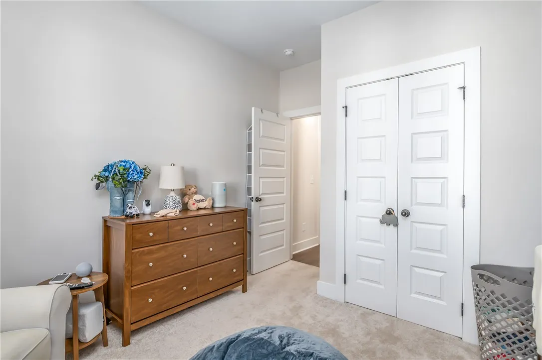 Plush carpeting anchors this versatile secondary bedroom featuring tall paneled closet doors.