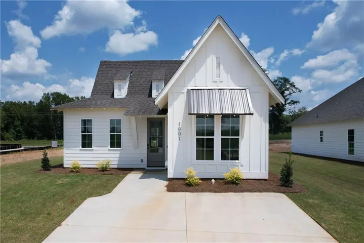 Board and batten siding meets a sharp metal awning in this modern cottage design.