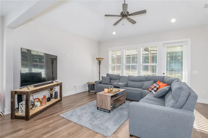 High vaulted ceilings and rich wood-texture flooring highlight this airy, light-filled gathering space.