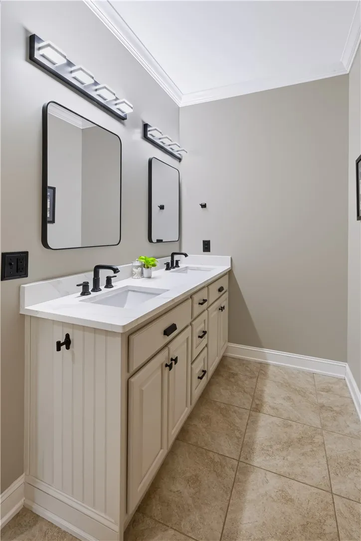 A classic double vanity offers ample under-sink storage set against neutral tiled flooring.
