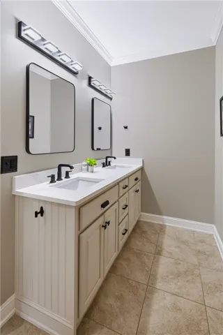 A classic double vanity offers ample under-sink storage set against neutral tiled flooring.