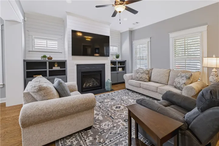 Built-in cabinetry flanks fireplace with media integration in lower cabinets & open shelving for photos, art & decorative pieces to be showcased.