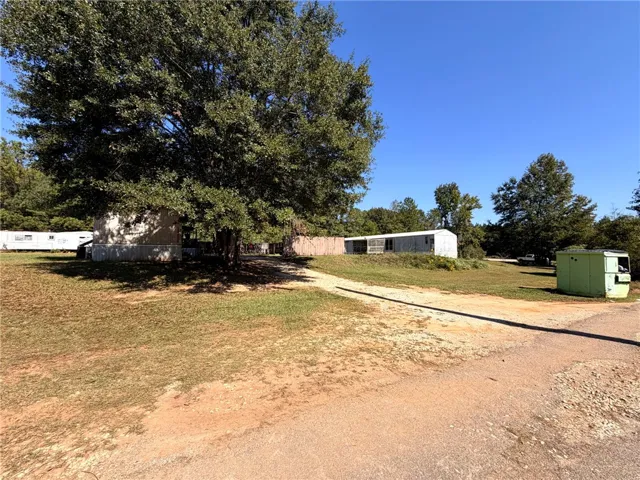 Mature shade trees and open green spaces frame this sprawling rural property.
