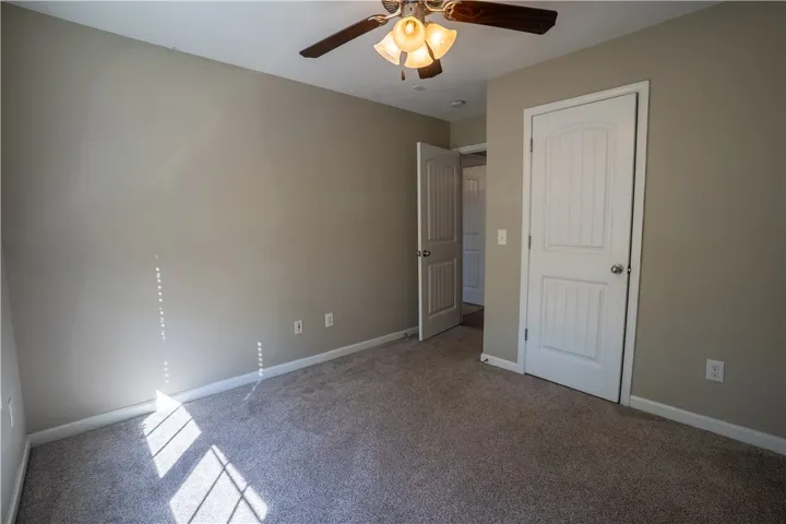 A comfortable bedroom space featuring soft carpeting and classic paneled doors.